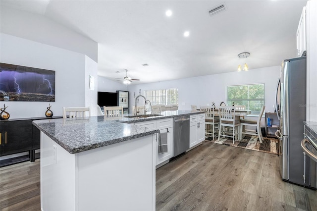 kitchen featuring appliances with stainless steel finishes, an island with sink, wood-type flooring, sink, and white cabinets