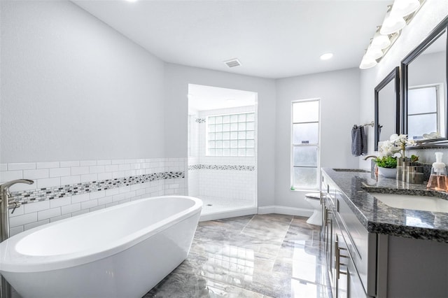 bathroom with independent shower and bath, vanity, and tile walls