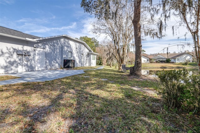 view of yard featuring central AC, a patio, and a water view