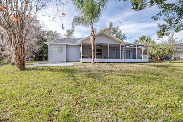 rear view of house with a lawn, a sunroom, a patio, and ceiling fan