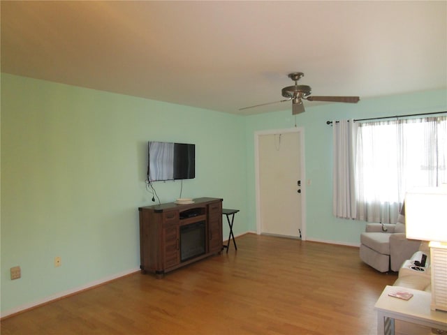 living room with ceiling fan and light hardwood / wood-style flooring