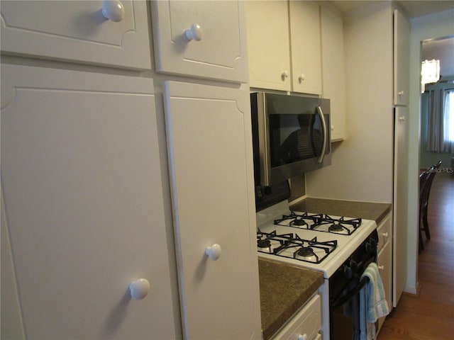 kitchen featuring range with gas stovetop, dark hardwood / wood-style floors, and white cabinets