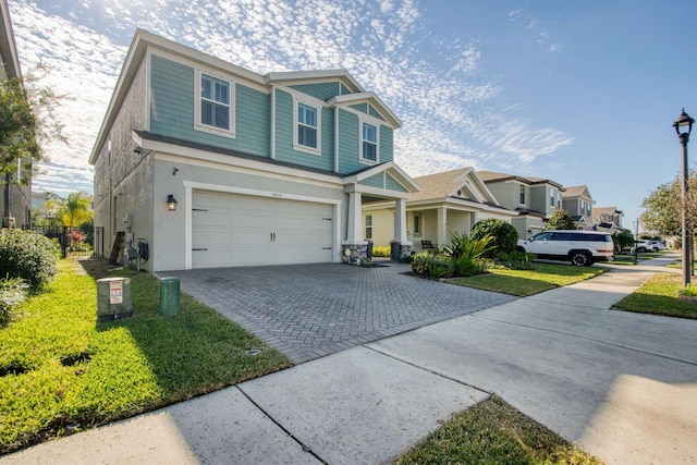 craftsman inspired home with a garage and a front lawn