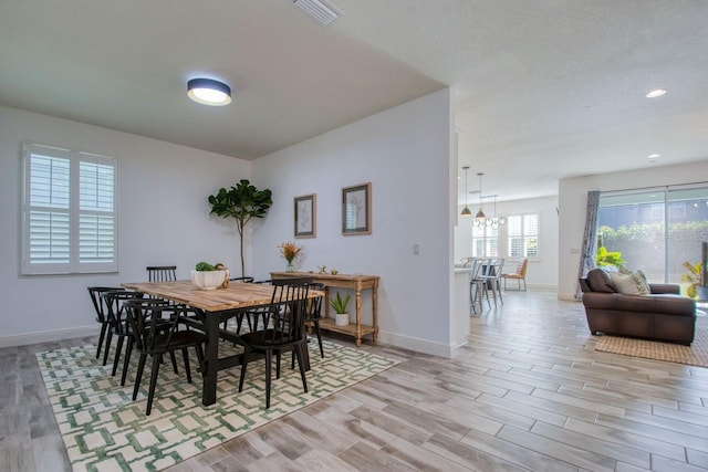 dining room with a chandelier and light wood-type flooring