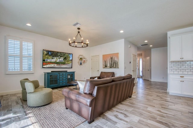 living room featuring a chandelier and light hardwood / wood-style flooring