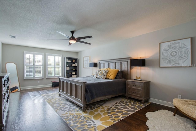 bedroom featuring dark hardwood / wood-style flooring, a textured ceiling, and ceiling fan