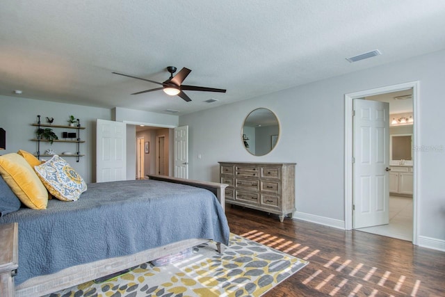 bedroom featuring ceiling fan, dark hardwood / wood-style flooring, ensuite bath, and a textured ceiling