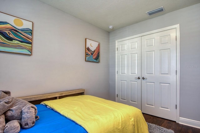 bedroom featuring dark hardwood / wood-style floors and a closet