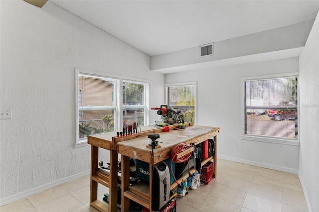 tiled dining area with lofted ceiling and a workshop area