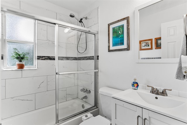 full bathroom with toilet, vanity, and shower / bath combination with glass door