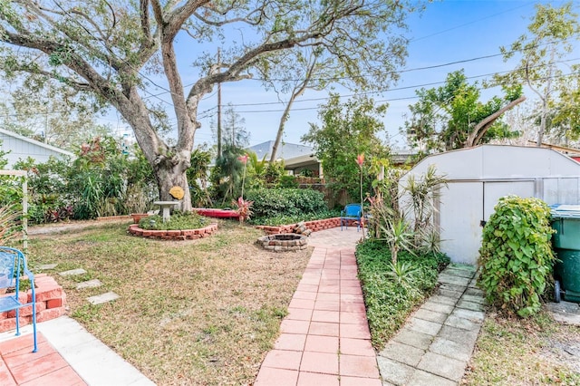 view of yard with a shed and a fire pit