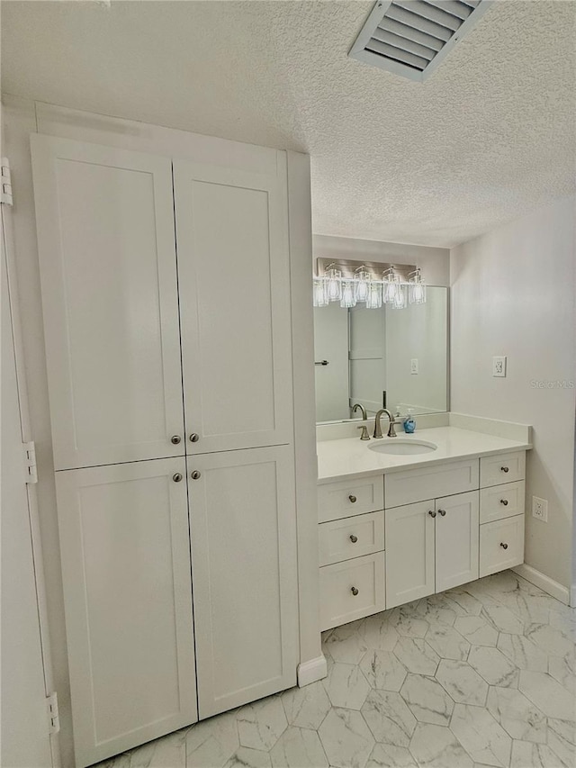 bathroom with vanity and a textured ceiling