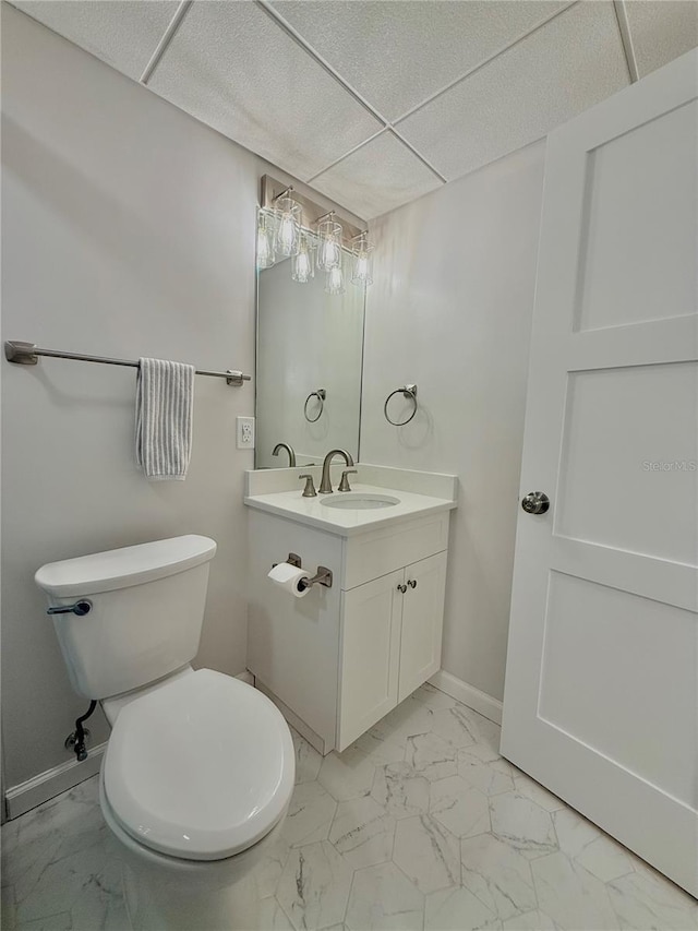 bathroom featuring vanity, a paneled ceiling, and toilet