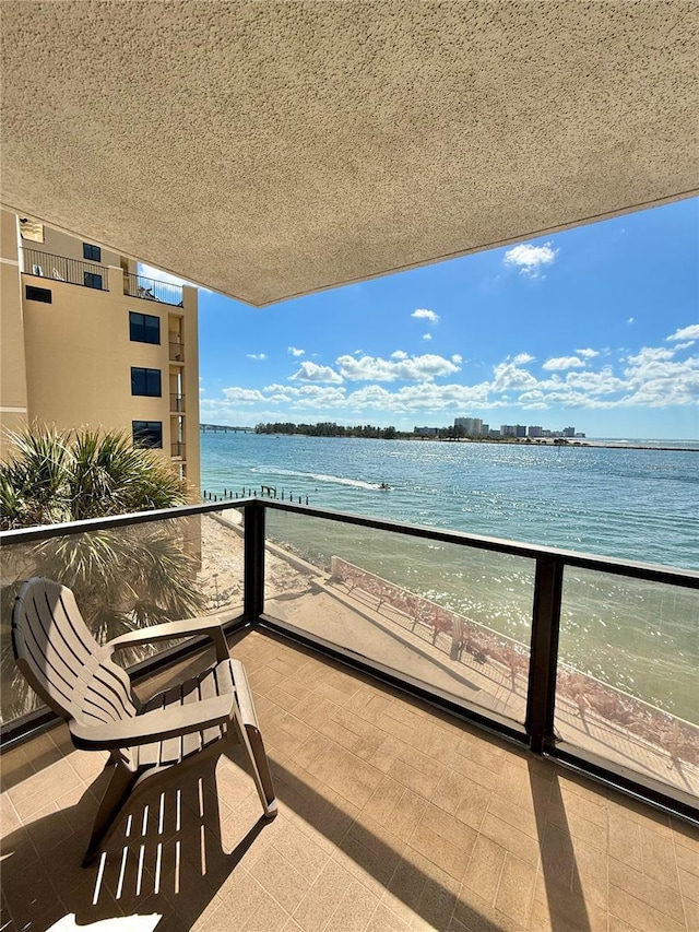 balcony with a water view and a beach view