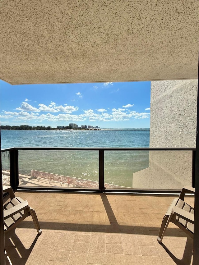 balcony featuring a beach view and a water view