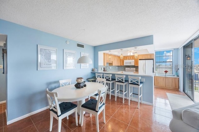 dining area featuring tile patterned flooring and a textured ceiling