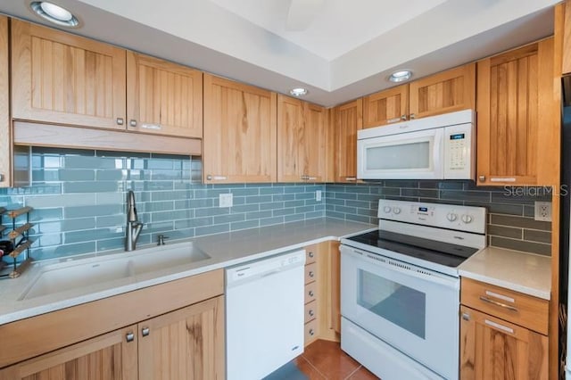 kitchen featuring white appliances, tile patterned floors, sink, and backsplash