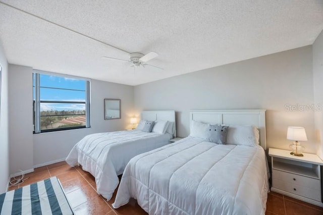 bedroom with a textured ceiling, tile patterned floors, and ceiling fan