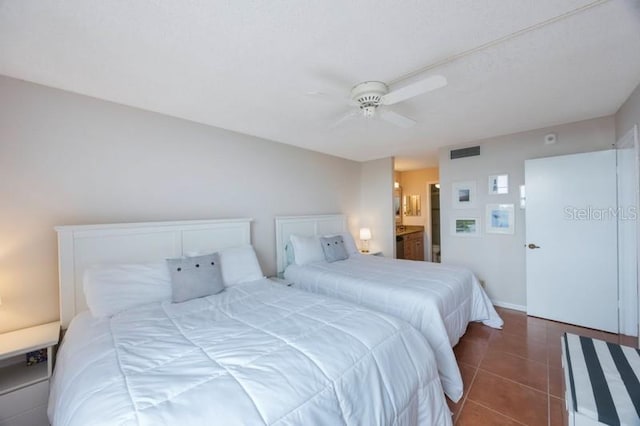 bedroom featuring dark tile patterned floors, ensuite bathroom, and ceiling fan