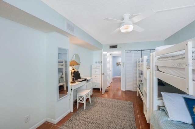 tiled bedroom featuring ceiling fan and a textured ceiling