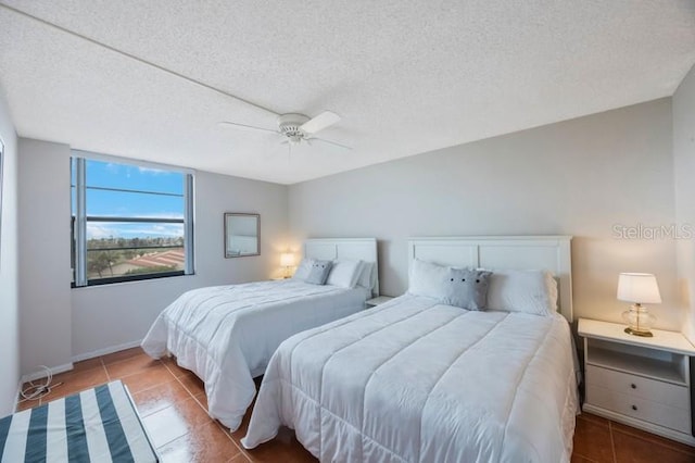 6051 Sun Blvd Unit 504, Saint Petersburg, FL 33715 - tiled bedroom featuring baseboards, a textured ceiling, and a ceiling fan
