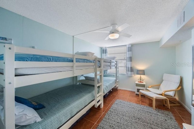 6051 Sun Blvd Unit 504, Saint Petersburg, FL 33715 - bedroom with tile patterned floors, baseboards, a textured ceiling, and a ceiling fan