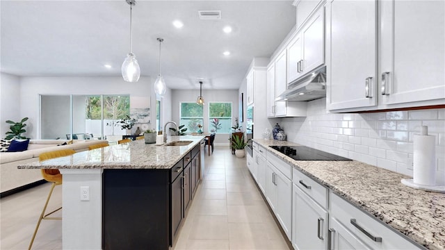 kitchen with pendant lighting, sink, white cabinetry, an island with sink, and black electric cooktop