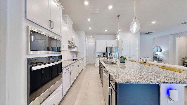 kitchen featuring white cabinetry, sink, decorative backsplash, and a spacious island