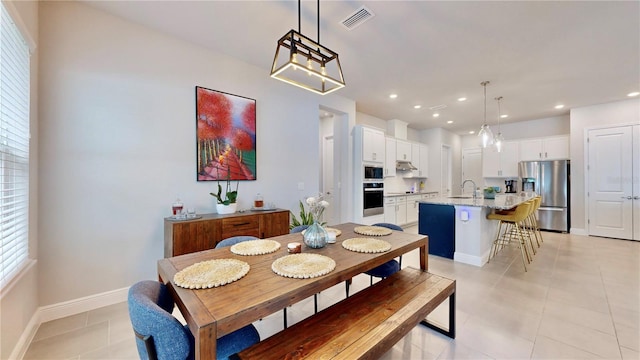 dining area featuring sink and light tile patterned floors