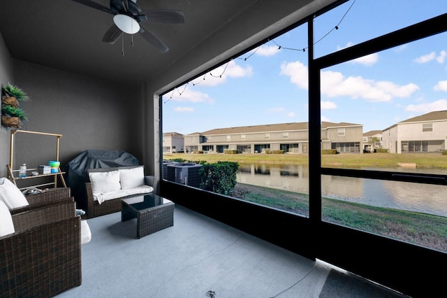 sunroom / solarium featuring a water view, ceiling fan, and plenty of natural light