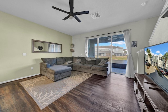 living room with dark wood-type flooring and ceiling fan