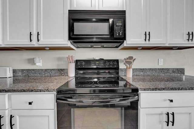 kitchen featuring white cabinetry, dark stone counters, and black appliances