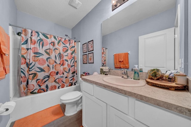 full bathroom featuring wood-type flooring, vanity, shower / tub combo, toilet, and a textured ceiling