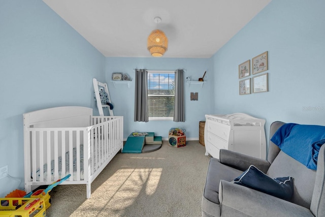 carpeted bedroom featuring a nursery area