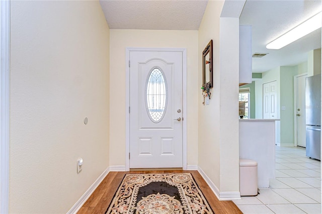 tiled entrance foyer featuring a textured ceiling