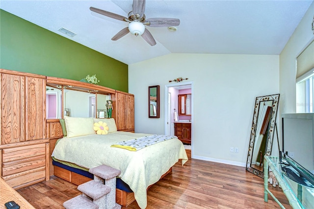 bedroom featuring vaulted ceiling, ceiling fan, connected bathroom, and hardwood / wood-style floors