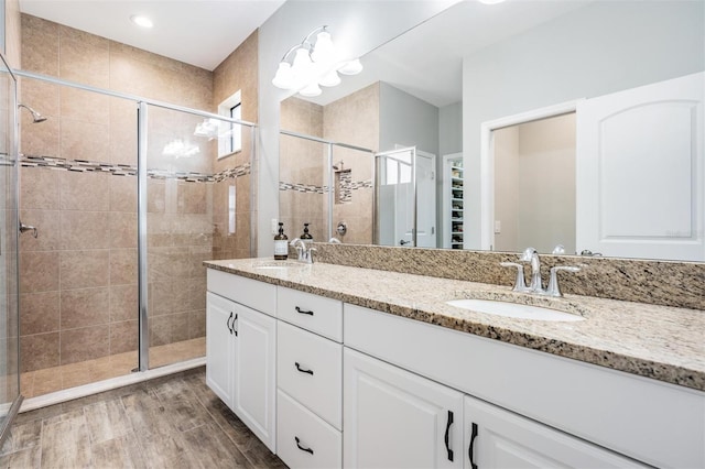 bathroom with vanity, hardwood / wood-style floors, and a shower with door