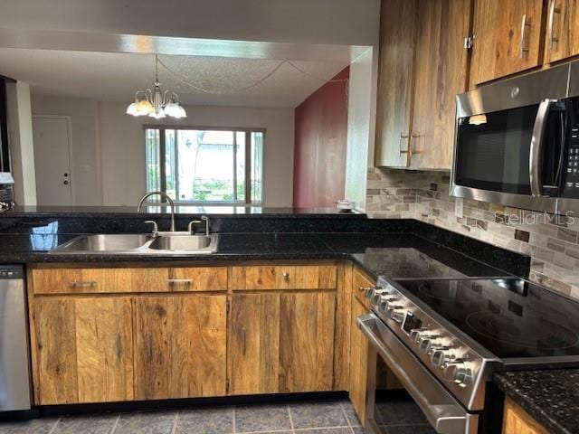 kitchen with stainless steel appliances, brown cabinets, a sink, and tasteful backsplash