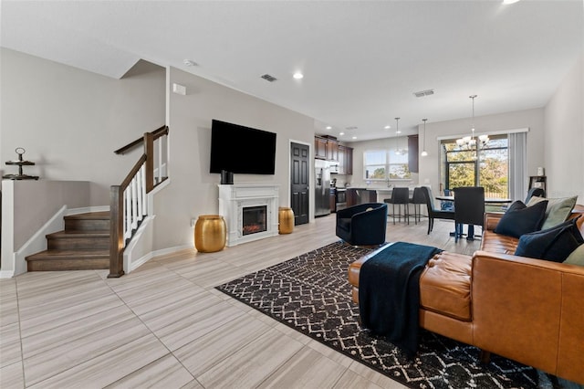 tiled living room with a notable chandelier