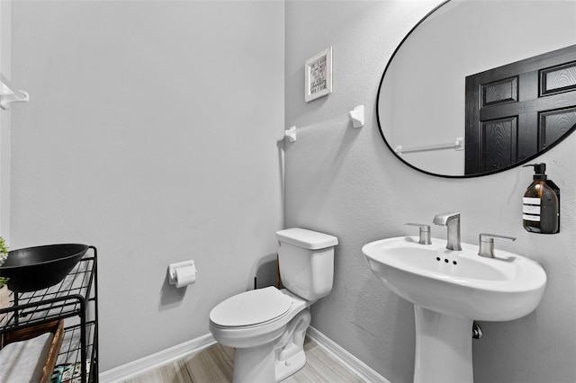 bathroom featuring sink, wood-type flooring, and toilet