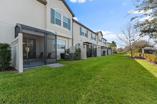 rear view of house featuring a yard and central AC