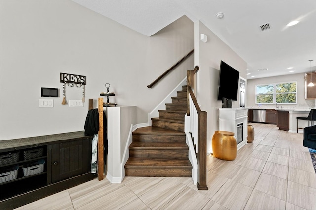 29913 Southwell Ln, Wesley Chapel, FL 33543 - stairs with a glass covered fireplace, tile patterned flooring, and recessed lighting
