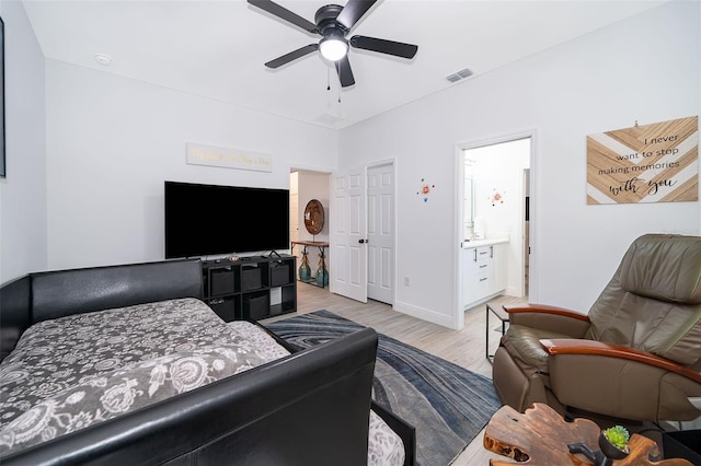 bedroom featuring light wood-type flooring, ceiling fan, and ensuite bathroom