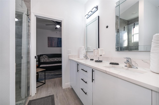 bathroom featuring vanity, hardwood / wood-style flooring, ceiling fan, and walk in shower