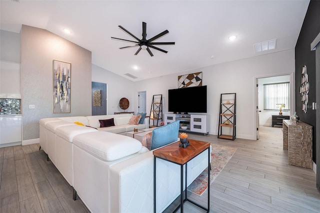 living room with ceiling fan, lofted ceiling, and light hardwood / wood-style flooring