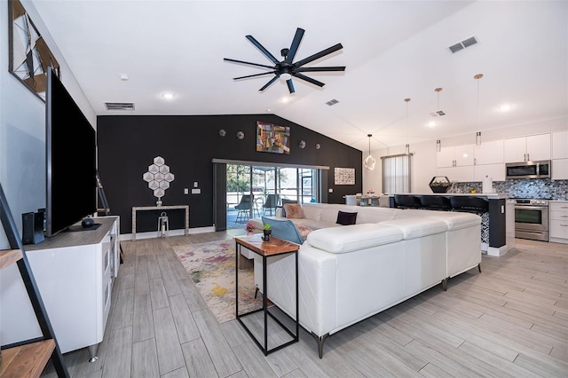 living room with lofted ceiling, light hardwood / wood-style flooring, and ceiling fan