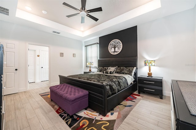 bedroom featuring a raised ceiling and ceiling fan