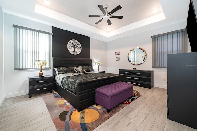 bedroom with ceiling fan and a raised ceiling