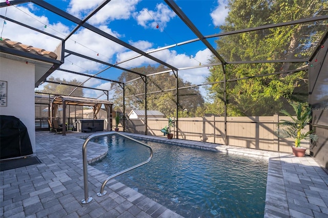 view of pool featuring a patio, a hot tub, and glass enclosure