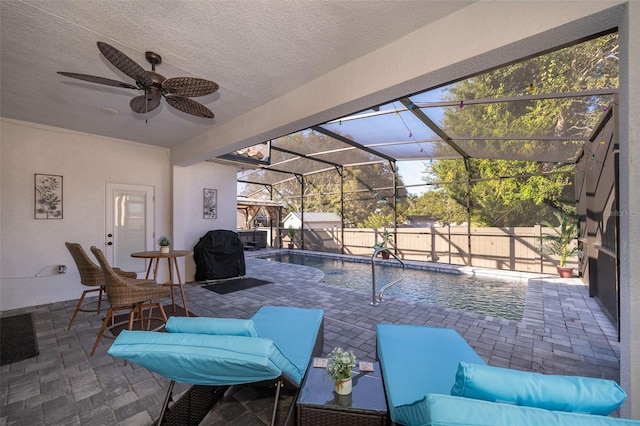 view of patio with outdoor lounge area, grilling area, ceiling fan, a fenced in pool, and glass enclosure